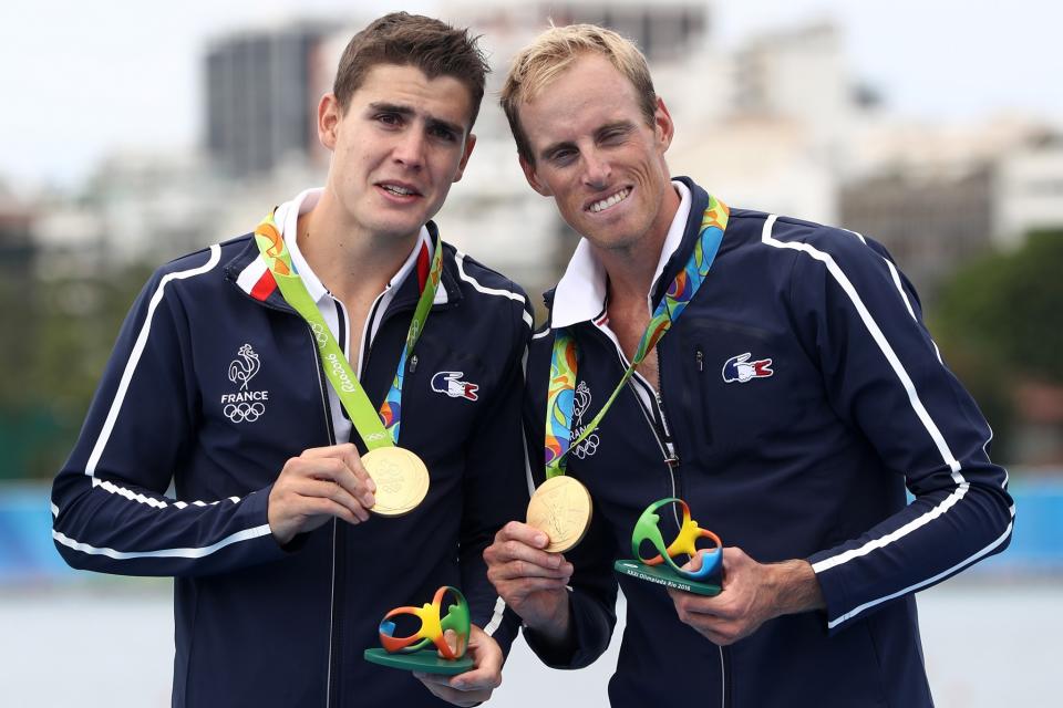 <p>Gold medalists Pierre Houin (L) and Jeremie Azou (R) of France celebrate on the podium at the medal ceremony for the Lightweight Men’s Double Sculls on Day 7 of the Rio 2016 Olympic Games at Lagoa Stadium. (Getty) </p>