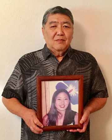 George Young holds a framed photo of his late daughter Tim Young in Hilo, Hawaii, U.S., July 30, 2018. Picture taken July 30, 2018. Courtesy Lynn Viale/Handout via REUTERS ATTENTION EDITORS - THIS IMAGE HAS BEEN SUPPLIED BY A THIRD PARTY. NO RESALES. NO ARCHIVES.