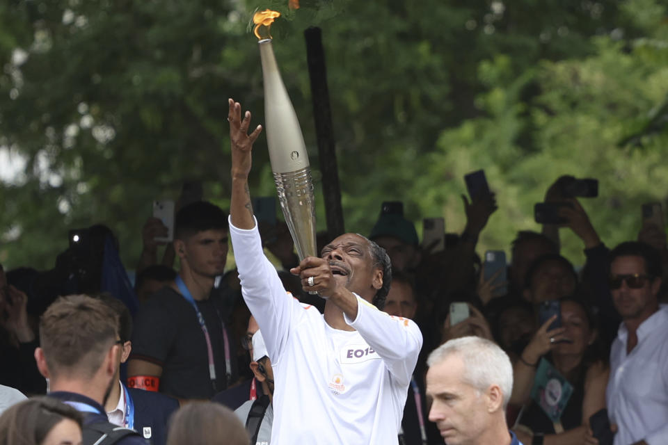 Snoop Dogg carries the Olympic torch before opening ceremony in Paris