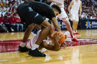 Marquette's Oso Ighodaro, top, and Wisconsin's Jahcobi Neath (0) battle for a loose ball during the first half of an NCAA college basketball game Saturday, Dec. 4, 2021, in Madison, Wis. (AP Photo/Andy Manis)