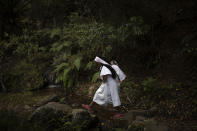 An Arhuaco Indigenous woman carries her baby in Nabusimake on the Sierra Nevada de Santa Marta, Colombia, Tuesday, Jan. 17, 2023. The life of the Arhuacos is closely tied to the Sierra Nevada de Santa Marta. Their white garments represent snow and their conical hats represent the snowy peaks of the Sierra Nevada. (AP Photo/Ivan Valencia)