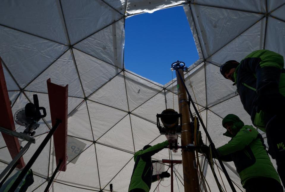 Members of the Ice Memory Foundation work to drill down into the ice and collect two ice cores (Reuters)