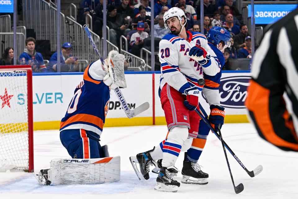 Apr 9, 2024; Elmont, New York, USA; New York Rangers left wing Chris Kreider (20) gets hit with the puck in front of New York Islanders goaltender Semyon Varlamov (40) during the first period at UBS Arena.