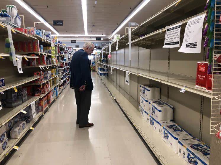 LOS ANGELES, CA - APRIL 7, 2020: A man shops at a Vons in Los Feliz on April 7, 2020, in Los Angeles, California. Signs around the store announce purchase limit, social distancing guidelines and that no returns are accepted. (Dania Maxwell / Los Angeles Times)
