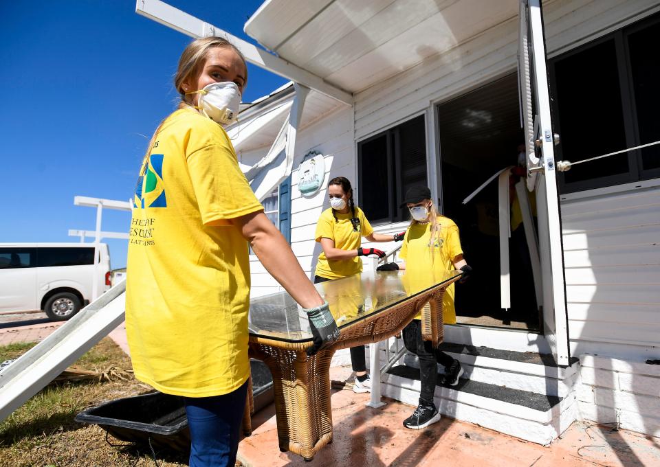 Volunteer workers, from the Crisis Cleanup program from the Church of Jesus Christ of Latter-day Saints, remmove water damaged flooring from a home in the Spring Creek Village neighborhood in Bonita Springs, Fla., on Saturday October 8, 2022. Hurricane Ian hit the southwest Florida coast on Wednesday September 28th.