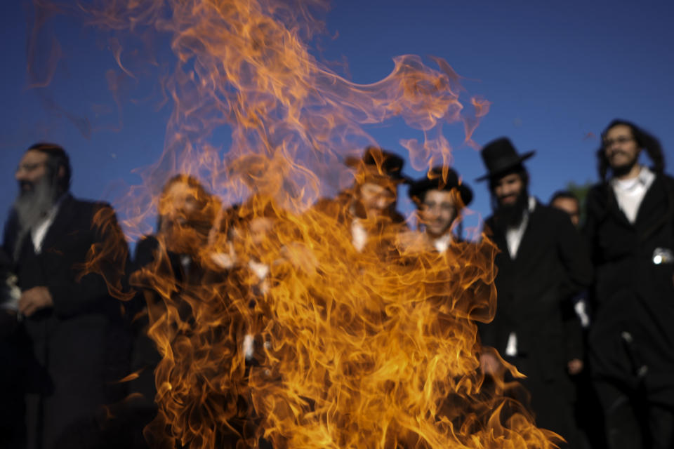 Ultra Orthodox Jews dance around a bonfire during Lag BaOmer celebrations at the traditional grave site of Rabbi Shimon Bar Yochai at Mount Meron northern Israel, Thursday, May 19, 2022. Israelis light bonfires during Lag BaOmer celebrations to commemorate the end of a plague said to have decimated Jews in Roman times. (AP Photo/Ariel Schalit)