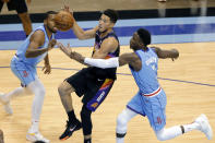 Phoenix Suns guard Devin Booker, middle, loses the ball on a shot attempt as he is fouled by Houston Rockets guard Victor Oladipo (7), while guard Sterling Brown, left, watches during the second half of an NBA basketball game Wednesday, Jan. 20, 2021, in Houston. (AP Photo/Michael Wyke)