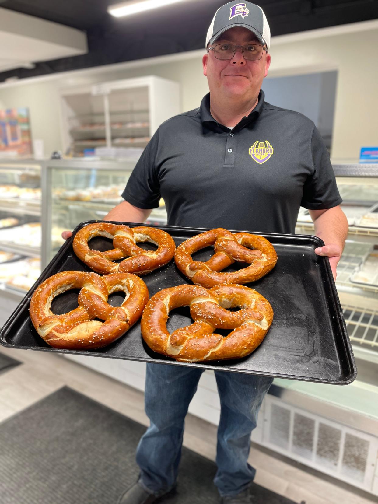 Baker Meister employee Rudolph Krause holds a tray of giant pretzels, which the Elkhorn bakery sells by the hundreds every week.