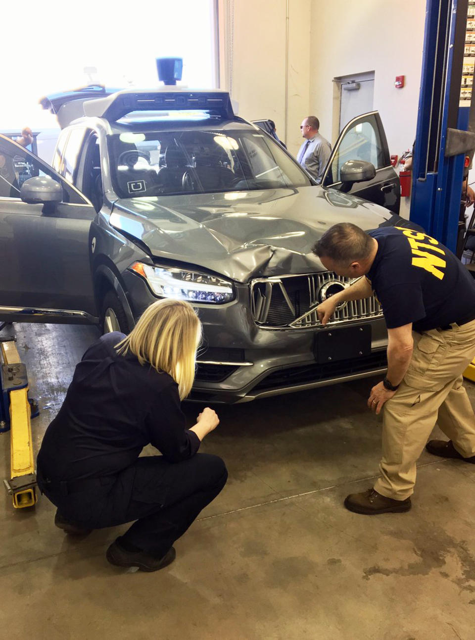 Investigators examine the driverless Uber SUV that fatally struck a woman in Tempe, Arizona. (National Transportation Safety Board via AP)