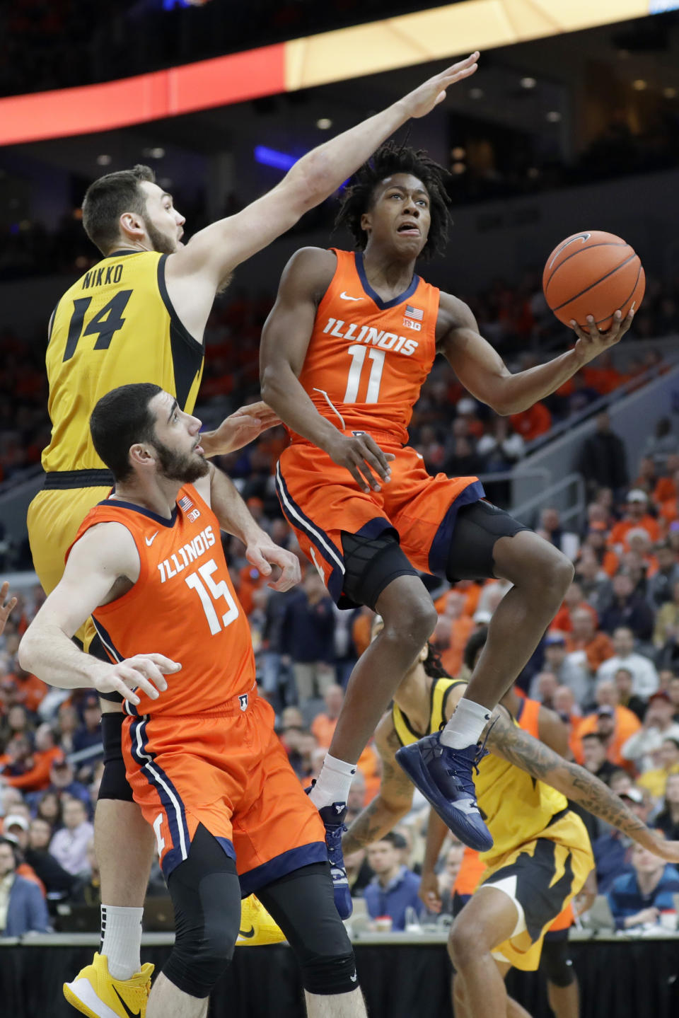 Illinois' Ayo Dosunmu (11) heads to the basket past teammate Giorgi Bezhanishvili (15) and Missouri's Reed Nikko (14) during the first half of an NCAA college basketball game Saturday, Dec. 21, 2019, in St. Louis. (AP Photo/Jeff Roberson)