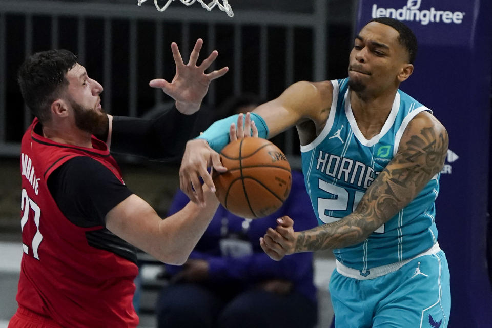 Portland Trail Blazers center Jusuf Nurkic vies for a loose ball with Charlotte Hornets forward P.J. Washington during the first half in an NBA basketball game on Sunday, April 18, 2021, in Charlotte, N.C. (AP Photo/Chris Carlson)