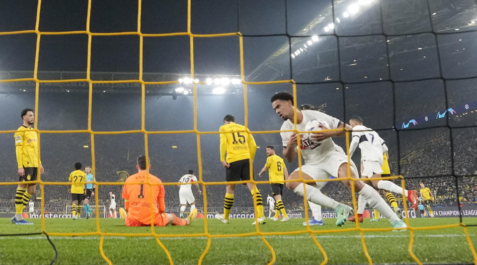 PSG's Warren Zaire-Emery takes the ball after he scored the 1-1 against Dortmund's goalkeeper Gregor Kobel during the Champions League Group F soccer match between Borussia Dortmund and Paris Saint-Germain at the Signal Iduna Park in Dortmund, Germany, Wednesday, Dec. 13 , 2023. (AP Photo/Martin Meissner)