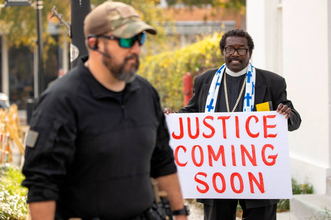 Rev. Raymond Johnson holds up his sign reading Justice Coming Soon as Alex Murdaugh walks in during the Alex Murdaugh double murder trial at the Colleton County Courthouse in Walterboro on day 25 of Monday, Feb. 27, 2023. Andrew J. Whitaker/The Post and Courier/Pool