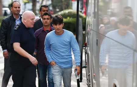 UK Border Force staff escort the first group of unaccompanied minors from the Jungle migrant camp in Calais to be brought to Britain as they arrive at an immigration centre in Croydon, south London, October 17, 2016. REUTERS/Peter Nicholls