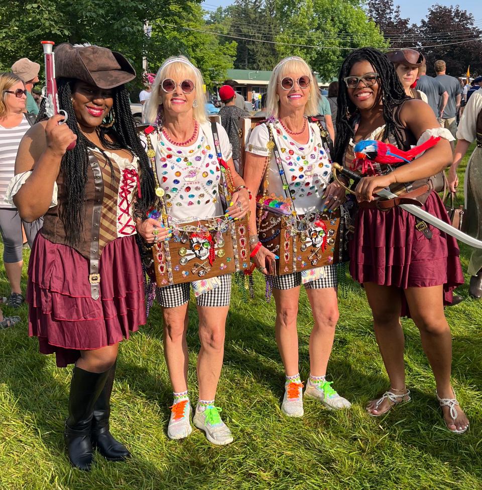 Two sets of twins dressed as pirates and treasure chests pose at the festival. 