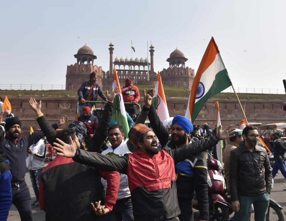 NEW DELHI, INDIA - JANUARY 26: Demonstrators at Red Fort during the farmers' tractor rally on Republic Day, on January 26, 2021 in New Delhi, India. Major scenes of chaos and mayhem at Delhi borders as groups of farmers allegedly broke barricades and police check posts and entered the national capital before permitted timings. Police used tear gas at Delhi's Mukarba Chowk to bring the groups under control. Clashes were also reported at ITO, Akshardham. Several rounds of talks between the government and protesting farmers have failed to resolve the impasse over the three farm laws. The kisan bodies, which have been protesting in the national capital for almost two months, demanding the repeal of three contentious farm laws have remained firm on their decision to hold a tractor rally on the occasion of Republic Day.(Photo by Sanjeev Verma/Hindustan Times via Getty Images)