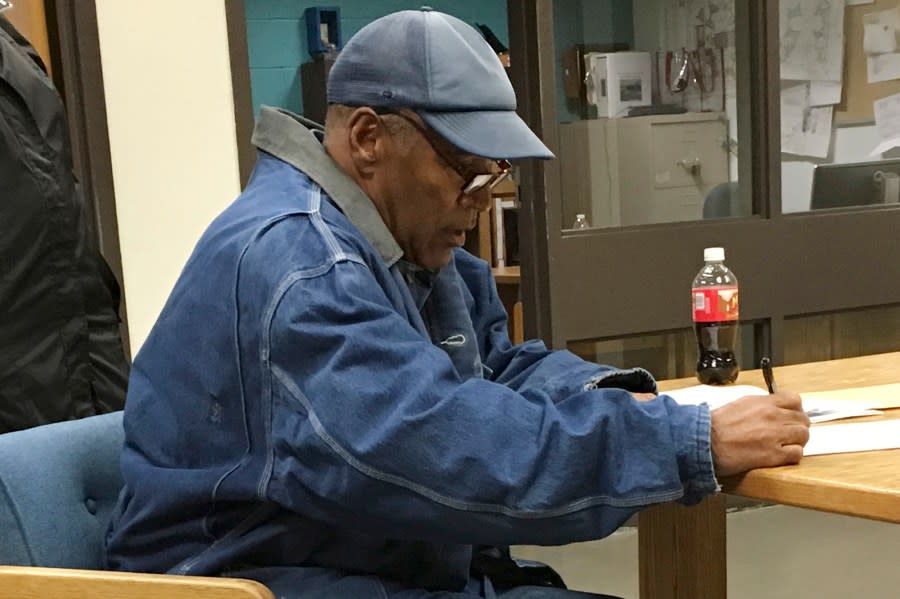 Former football legend O.J. Simpson signs documents at the Lovelock Correctional Center, Saturday, Sept. 30, 2017, in Lovelock, Nev. Simpson was released from the Lovelock Correctional Center in northern Nevada early Sunday, Oct. 1, 2017. (Brooke Keast/Nevada Department of Corrections via AP)