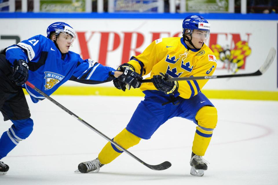 Finland's Aleksi Mustonen (L) gets caught on Sweden's Andreas Johnson's glove during their IIHF World Junior Championship Group B preliminary round ice hockey match at Malmo Arena in Malmo, December 28, 2013. REUTERS/Ludvig Thunman/TT News Agency (SWEDEN - Tags: SPORT ICE HOCKEY) ATTENTION EDITORS - THIS IMAGE HAS BEEN SUPPLIED BY A THIRD PARTY. IT IS DISTRIBUTED, EXACTLY AS RECEIVED BY REUTERS, AS A SERVICE TO CLIENTS. SWEDEN OUT. NO COMMERCIAL OR EDITORIAL SALES IN SWEDEN. NO COMMERCIAL SALES