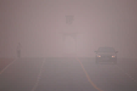 A car makes its way amidst the heavy smog in New Delhi, India, November 6, 2016. REUTERS/Adnan Abidi