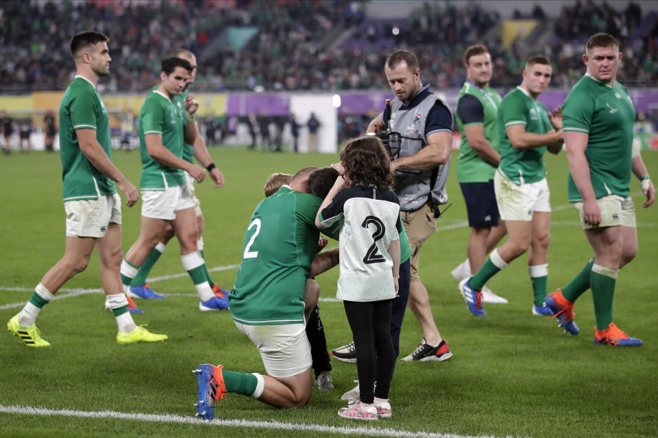 Ireland's Rory Best comforts his children after the Rugby World Cup quarterfinal match at Tokyo Stadium between New Zealand and Ireland in Tokyo, Japan, Saturday, Oct. 19, 2019. New Zealand won 46-14. (AP Photo/Jae C. Hong)