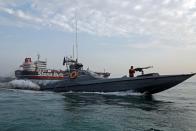 A boat of the Iranian Revolutionary Guard sails next to Stena Impero at Bandar Abbas port