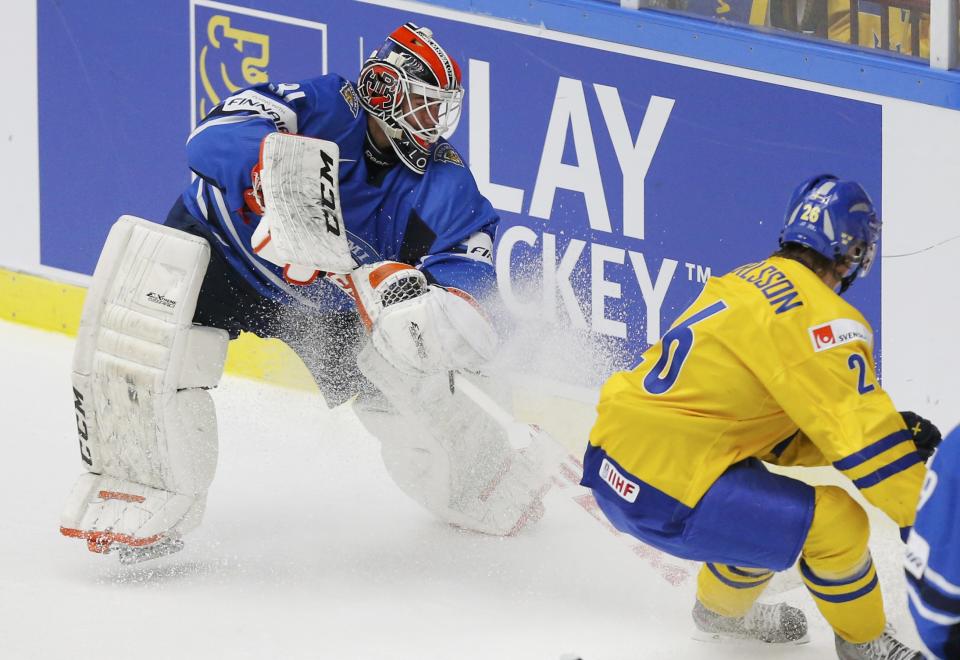 Finland's goalie Juuse Saros (L) comes out to play the puck against Sweden's Erik Karlsson during the second period of their IIHF World Junior Championship gold medal ice hockey game in Malmo, Sweden, January 5, 2014. REUTERS/Alexander Demianchuk (SWEDEN - Tags: SPORT ICE HOCKEY)