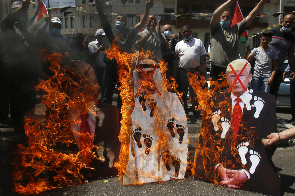 FILE - In this Aug. 14, 2020 file photo, Palestinians burn pictures of U.S. President Donald Trump, Abu Dhabi Crown Prince Mohammed bin Zayed al-Nahyan and and Israeli Prime Minister Benjamin Netanyahu during a protest against the United Arab Emirates' deal with Israel, in the West Bank city of Nablus. For the first time in more than a quarter-century, a U.S. president will host a signing ceremony, Tuesday, Aug. 15, between Israelis and Arabs at the White House, billing it as an "historic breakthrough" in a region long known for its stubborn conflicts. .(AP Photo/Majdi Mohammed, File)