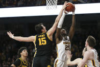 Iowa's Ryan Kriener (15) blocks the shot of Minnesota's Daniel Oturu (25) during an NCAA college basketball game Sunday, Feb. 16, 2020, in Minneapolis. (AP Photo/Stacy Bengs)
