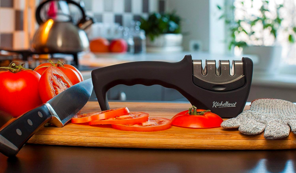 the knife sharpener on a counter next to slices of tomato