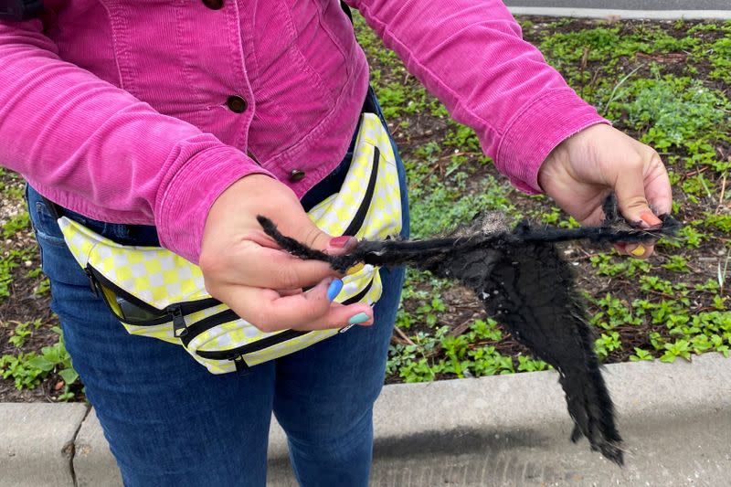 A spectator holds a piece of debris which was blown 5 miles from the site where SpaceX test rocket SN11 exploded upon landing, in Boca Chica