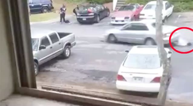 As the car reverses the woman is dragged under the wheels. Photo: LiveLeak