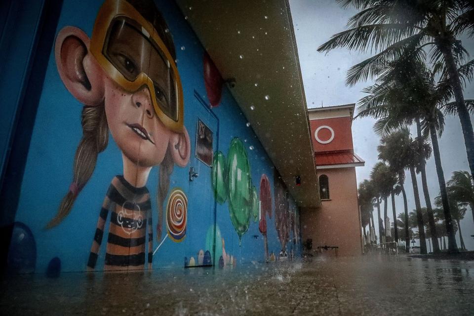 Rain falls near mural at the Lake Worth beach casino early Saturday morning June 4, 2022. Heavy rainfall and possible flooding is expected throughout the day.