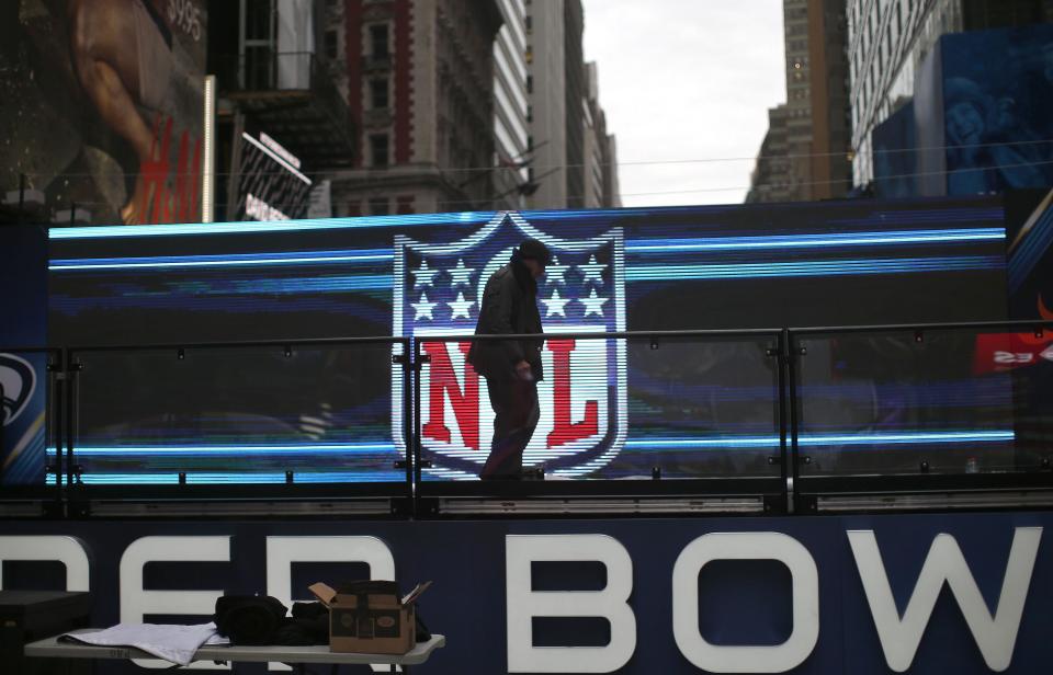 A worker walks on a stage in front of the NFL logo in New York's Times Square January 27, 2014. New Jersey's MetLife Stadium will host the first outdoor, cold-weather Super Bowl February 2. As part of festivities, the NFL is sponsoring activities along 'Super Bowl Boulevard', located on Broadway between 34th and 47th streets in Manhattan. REUTERS/Mike Segar (UNITED STATES - Tags: SOCIETY SPORT FOOTBALL)