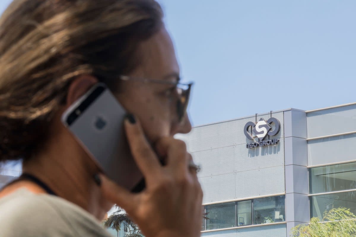 An Israeli woman uses her iPhone in front of the building housing the Israeli NSO group, on August 28, 2016 (AFP via Getty Images)
