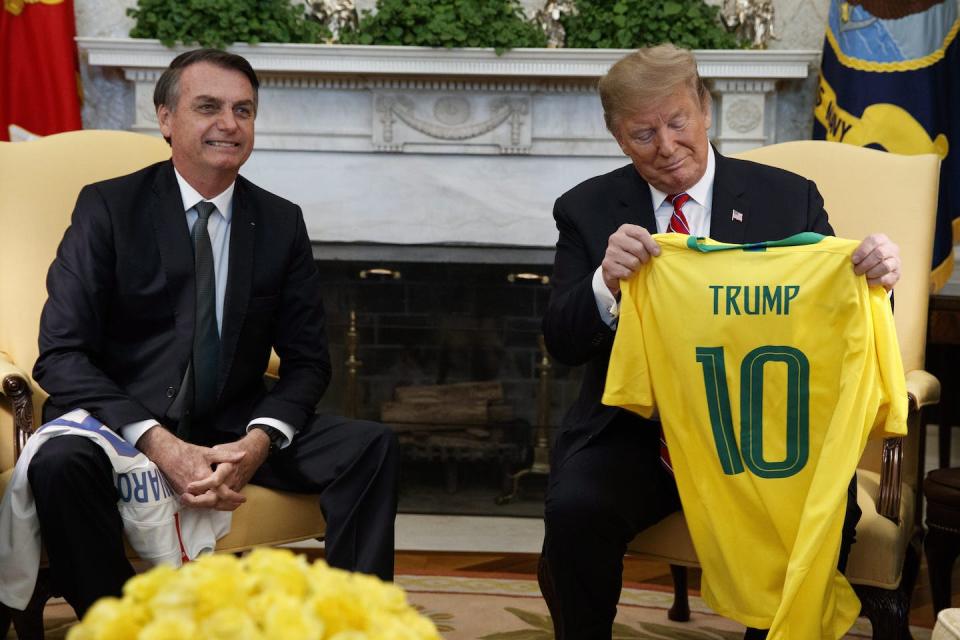 Jair Bolsonaro présente à Donald Trump un maillot de l’équipe nationale brésilienne de football dans le bureau ovale de la Maison-Blanche en mars 2019. (AP Photo/Evan Vucci)