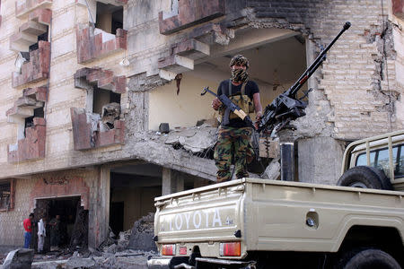 A police trooper mans a machine gun mounted on a patrol truck at the site of a car bomb attack outside the Finance Ministry offices in the southern port city of Aden, Yemen November 29, 2017. REUTERS/Fawaz Salman