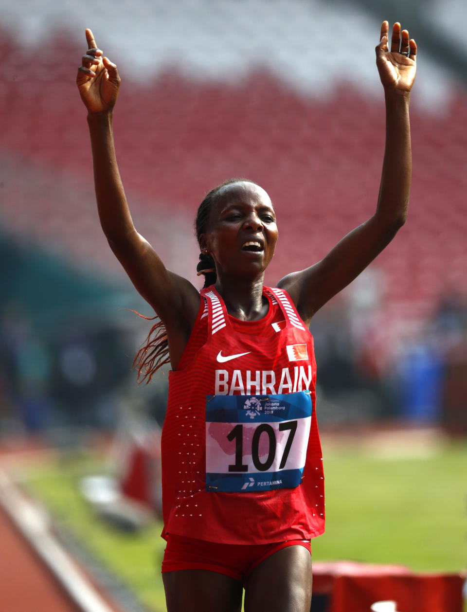 Bahrain's Rose Chelimo crosses the finish line to win the women's marathon during the athletics competition at the 18th Asian Games in Jakarta, Indonesia, Sunday, Aug. 26, 2018. (AP Photo/Bernat Armangue)