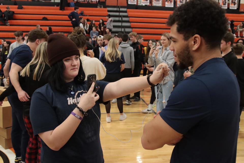 Lauren Bomia, a Tecumseh High School freshman, interviews Isaiah Gash, a running back on the University of Michigan football team, at the end of an assembly Friday, March 24, 2023, at Tecumseh High School with the Michigan Army National Guard and University of Michigan student-athletes.