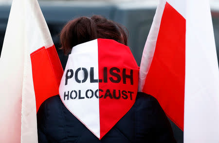 A woman hold polish flags as she arrives at the former Nazi German concentration and extermination camp Auschwitz, during the ceremonies marking the 74th anniversary of the liberation of the camp and International Holocaust Victims Remembrance Day, in Oswiecim, Poland, January 27, 2019. REUTERS/Kacper Pempel