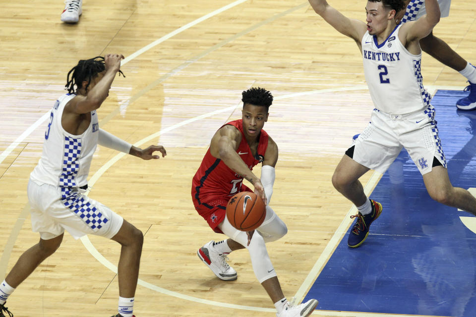 Richmond's Isaiah Wilson, middle, passes the ball near Kentucky's B.J. Boston, left, and Devin Askew (2) during the first half of an NCAA college basketball game in Lexington, Ky., Sunday, Nov. 29, 2020. (AP Photo/James Crisp)