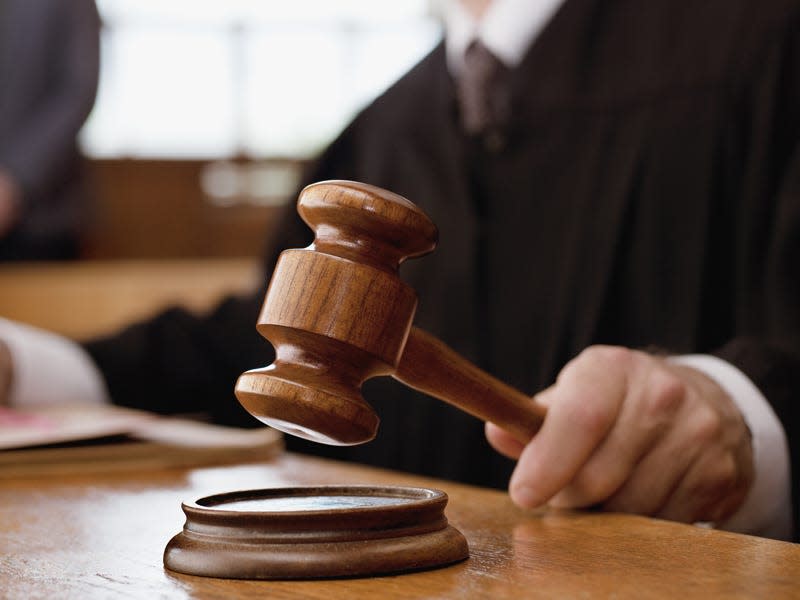 A judge holding a gavel in a courtroom.