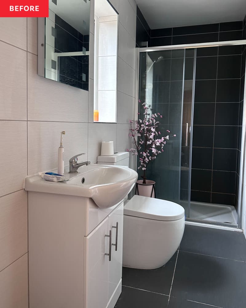 A bathroom with a black tile floor and shower.