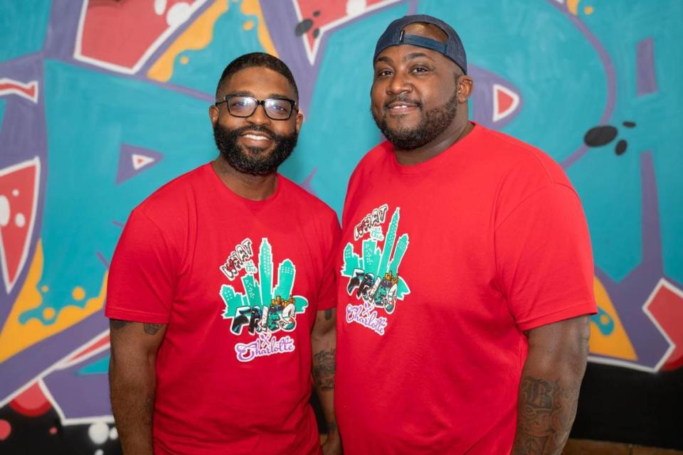 What The Fries owners Jamie Barnes and Greg Williams in front of art by Swych19 inside their restaurant in Pineville.