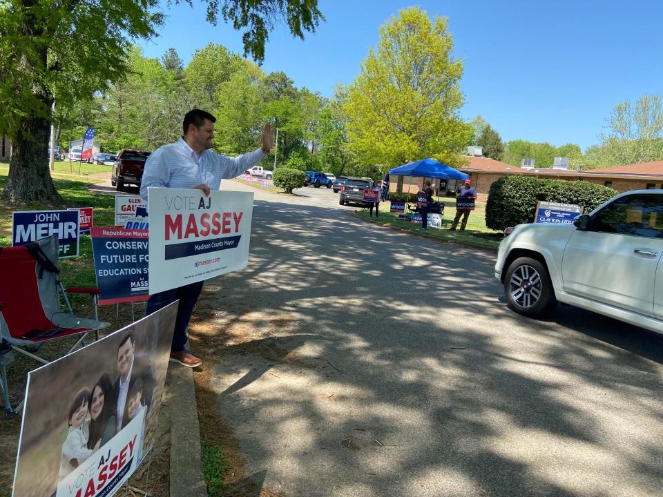Madison County Mayor candidate A.J. Massey waves to voters as they drive into the parking lot for the Madison County Election Commission on April 27, 2022.