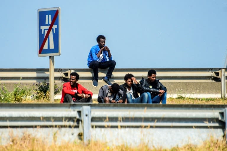 Migrants wait along the ring road leading to the port of Calais, northern France, in June 2017