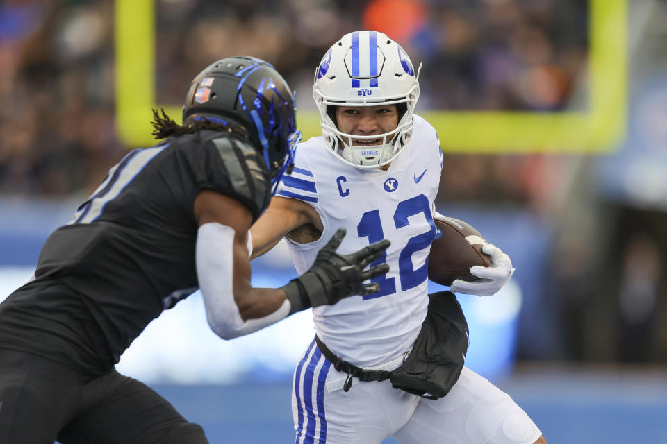 BYU wide receiver Puka Nacua (12) stiff-arms Boise State cornerback Tyreque Jones, left, after a catch in the first half of an NCAA college football game, Saturday, Nov. 5, 2022, in Boise, Idaho. (AP Photo/Steve Conner)