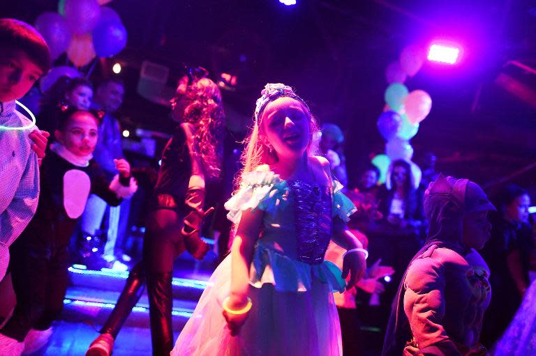 Children dance during an electronic dance music party at a night club in New York on October 26, 2014