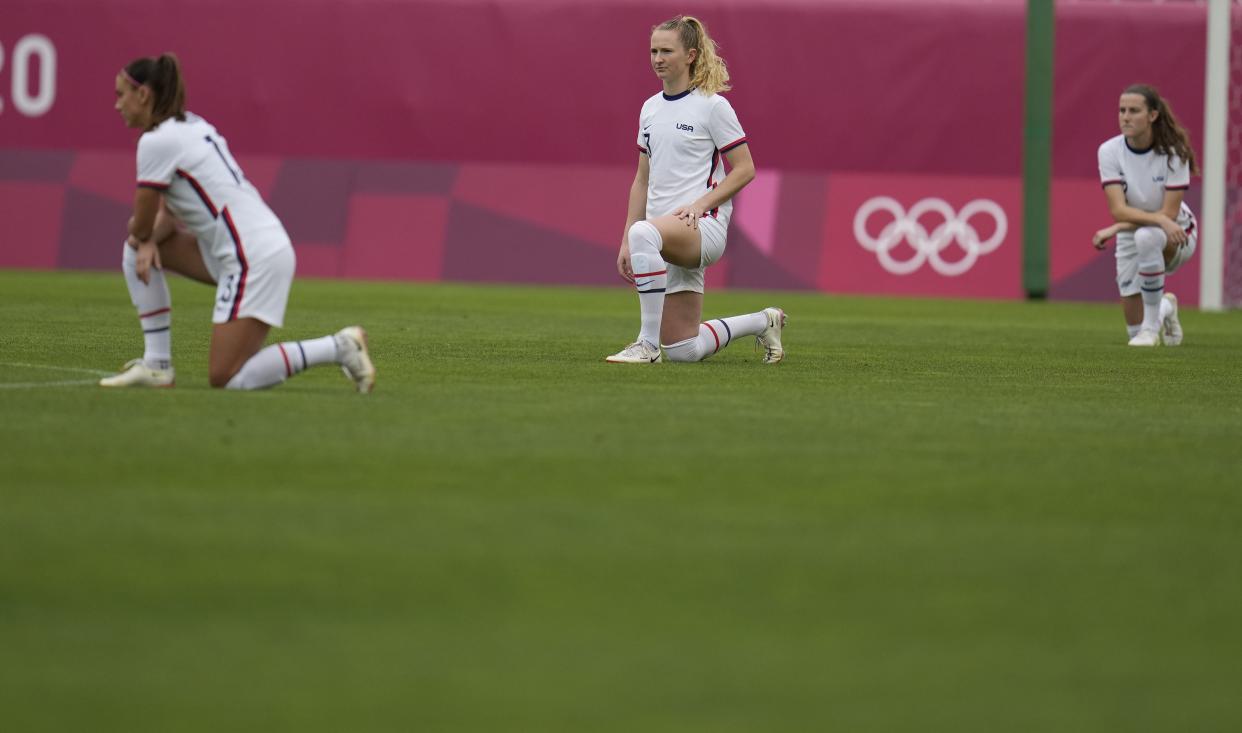 United States players kneel prior to their women's soccer match against Australia at the 2020 Summer Olympics, Tuesday, July 27, 2021, in Kashima, Japan.