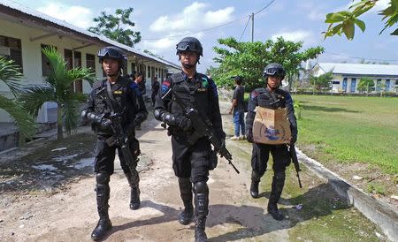 Anti-terror police walk as one carries a box with items retrieved from the house of a suspected militant involved in Thursday's attack in Jakarta, in Sampit, Indonesia Central Kalimantan province, January 16, 2016 in this photo taken by Antara Foto. REUTERS/Norjani/Antara Foto