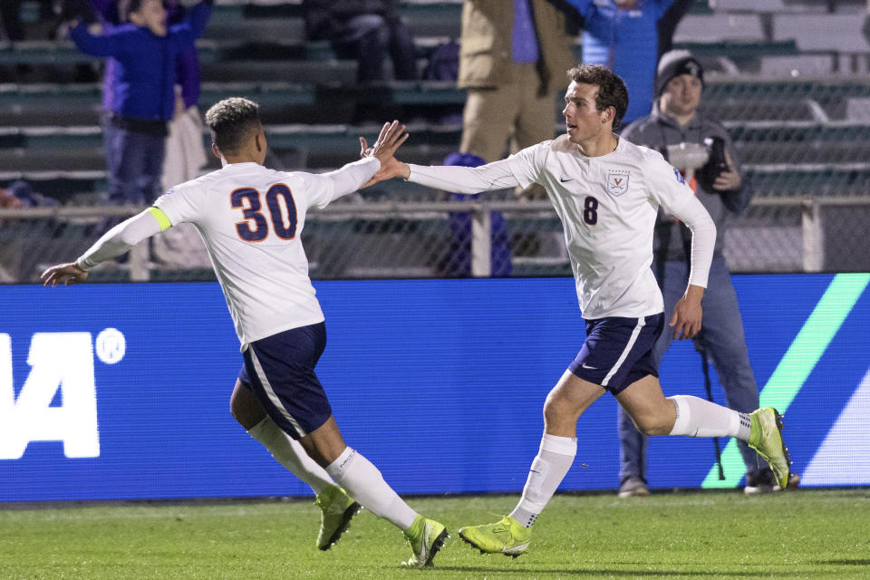 Virginia's Joe Bell (8) celebrates with Robin Afamefuna (30) after scoring a goal during the first half of the NCAA college soccer championship against Georgetown in Cary, N.C., Sunday, Dec. 15, 2019. (AP Photo/Ben McKeown)